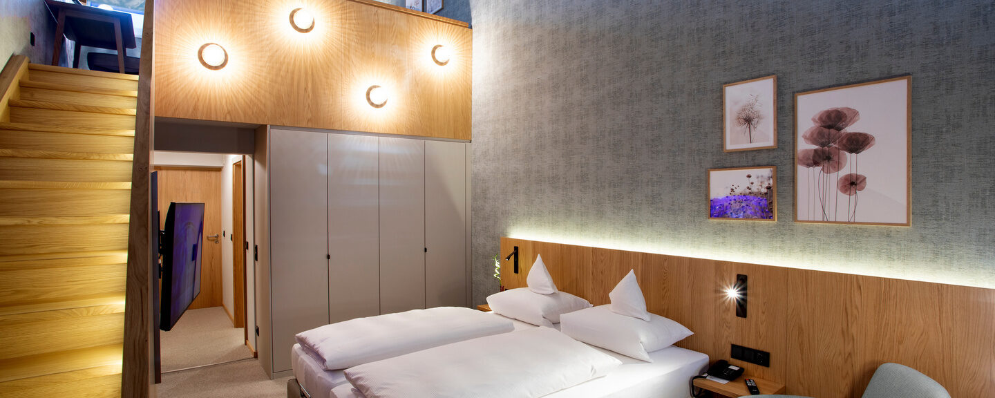 Der Blick auf die Galerie des Galeriezimmers Komfort Deluxe mit einem Schreibtisch und einer Decke an der Wand