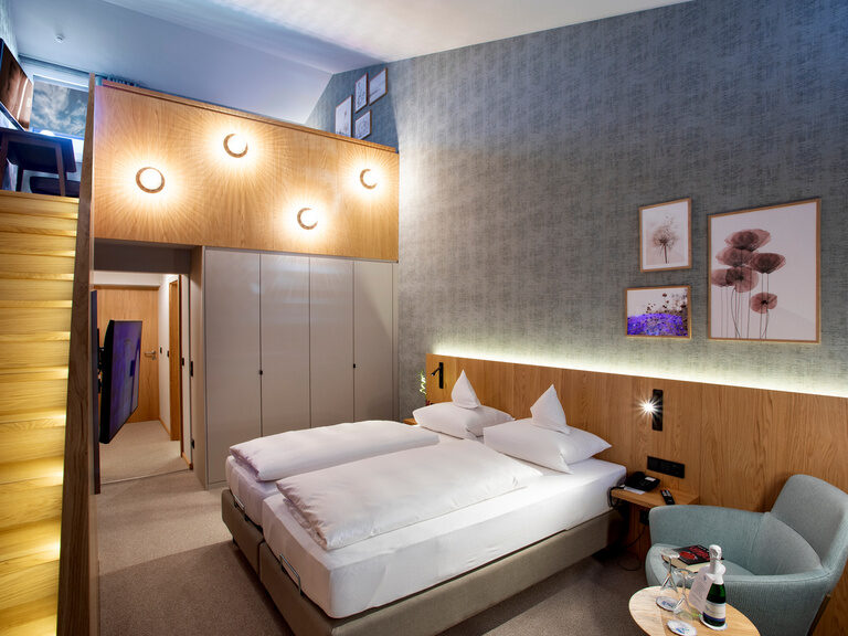 Der Blick auf die Galerie des Galeriezimmers Komfort Deluxe mit einem Schreibtisch und einer Decke an der Wand