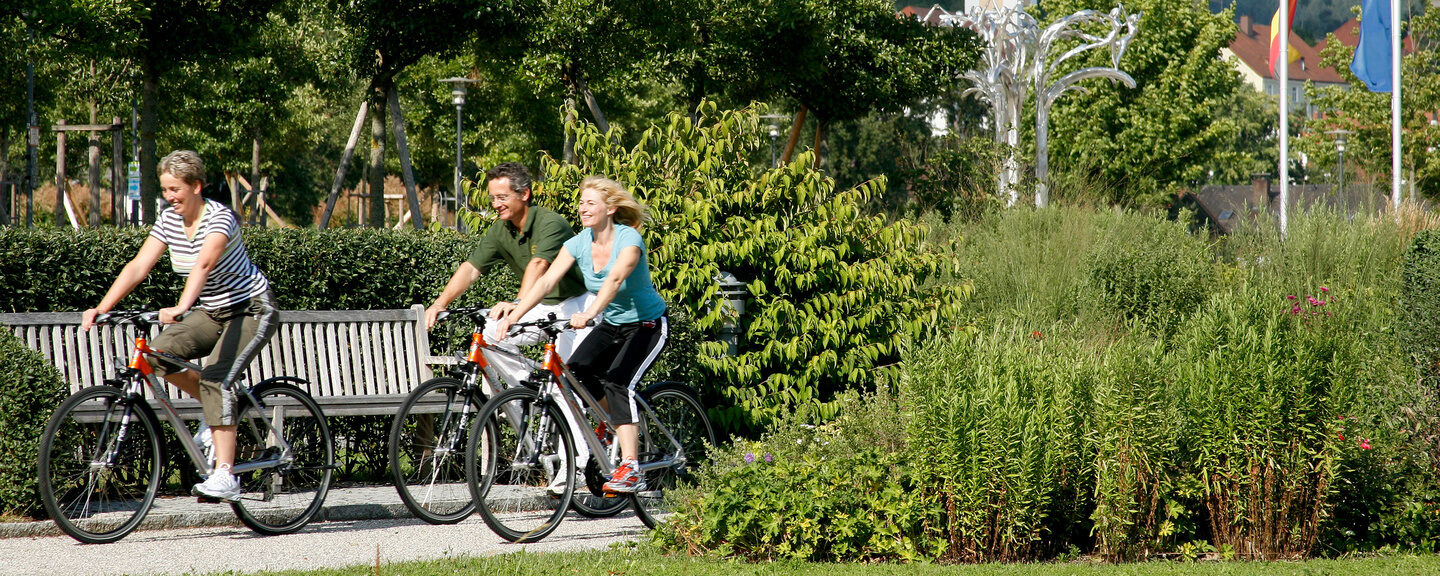 Eine Gruppe Radfahrer f&auml;hrt durch einen Park in der Umgebung des Thermenhotels Hofmark