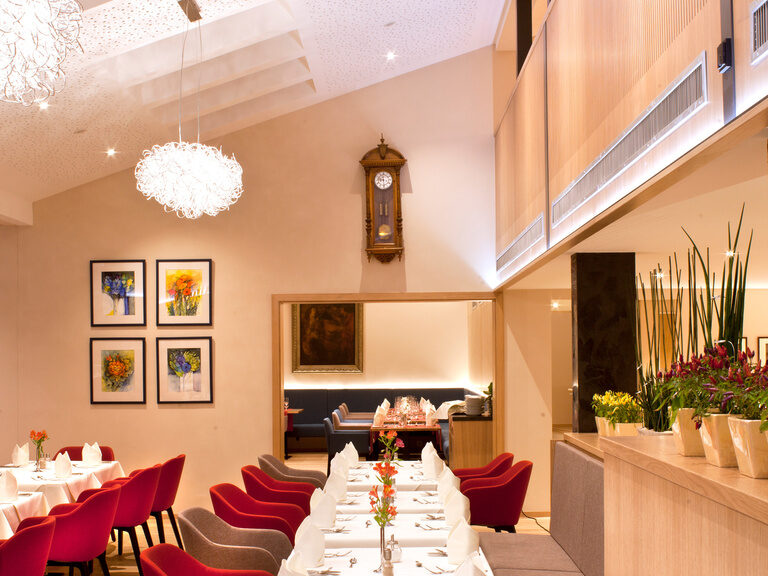 Die roten Stühle bieten einen schönen Kontrast zu den weißen Tischdecken im Thermenhotel Hofmark