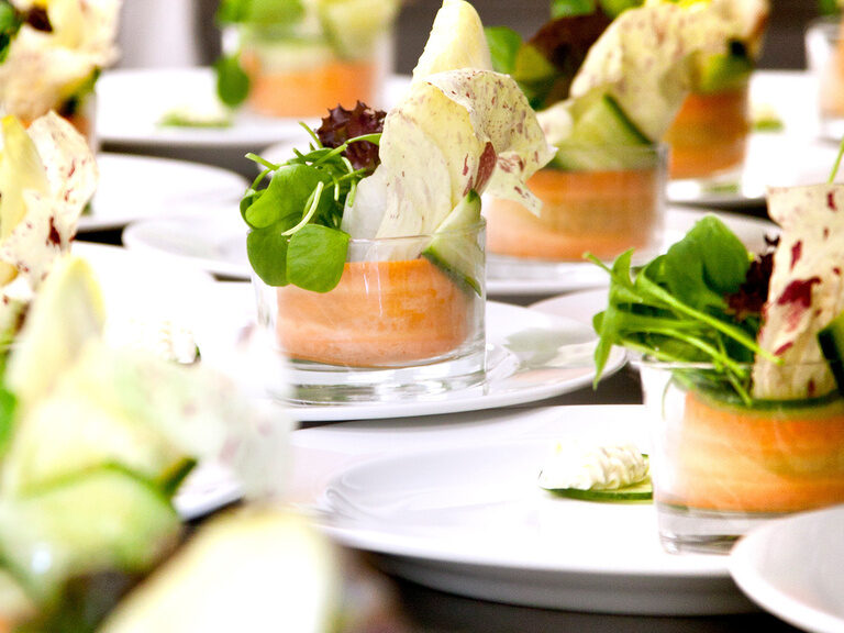 Auf einem Tisch stehen eine Menge Teller mit schön angerichteten Speißen